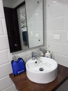 La salle de bains est pourvue d'un lavabo blanc et d'un miroir. dans l'établissement Paramount 3-Bedroom Apartment with Parking, à San Felipe de Puerto Plata