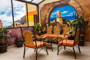 patio ze stołem i krzesłami oraz malowidłem ściennym w obiekcie Hostal Sonia w mieście Copacabana
