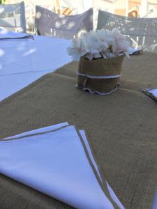 een tafel met een vaas met bloemen erop bij Rosys Little Village in Skala