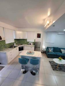 a kitchen and living room with a blue couch at Chalet Belizomi Tropical Villas Studio Villa #3 in Gros Islet