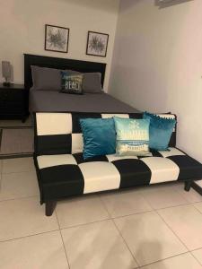 a couch with pillows on it in a bedroom at Chalet Belizomi Tropical Villas Studio Villa #3 in Gros Islet