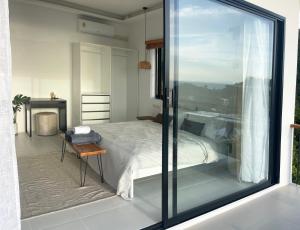 a bedroom with a bed and a glass window at Infinity Villa in Salad Beach