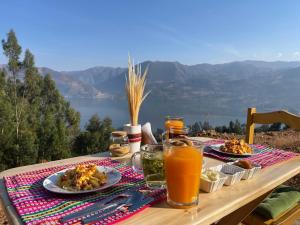 a table with plates of food and drinks on it at Pacucha Glamping in Andahuaylas