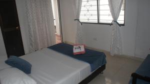 Habitación pequeña con cama y ventana en Guacamayas, en Santa Marta