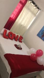 a bedroom with a bed with red and white balloons at Guacamayas in Santa Marta
