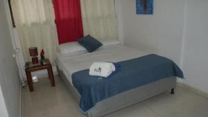 una piccola camera con letto e finestra di Guacamayas a Santa Marta