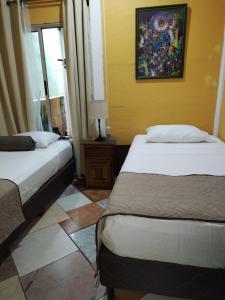 sypialnia z 2 łóżkami i obrazem na ścianie w obiekcie Villa Gabriela, Casa Tucan w mieście Liberia