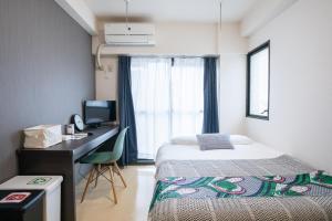 ein Schlafzimmer mit Bett, Schreibtisch und Fenster in der Unterkunft Escort Haruyoshi in Fukuoka