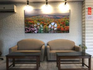 a waiting room with two chairs and a painting on the wall at KANCHAN DEEP in Jaipur
