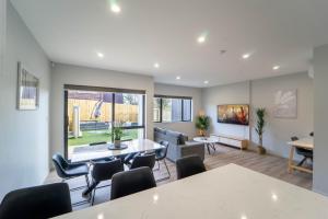 a living room with a table and chairs at Modern Sunnyhills Town House in Auckland