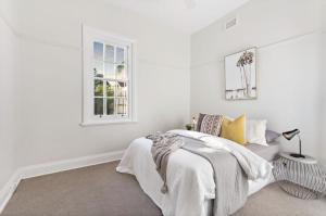 Habitación blanca con cama y ventana en NEWLY RENOVATED LARGE 3.5 BDRM HOUSE! BEST OF MELB en Melbourne