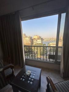 - un salon avec une grande fenêtre offrant une vue dans l'établissement رواد الزمالك 2 إطلالة ع النيل و الابراج, au Caire