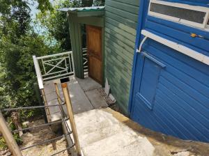 a blue and green house with a blue door at Frente al mar APARTO STUDIO BLUE LIZARD in Providencia