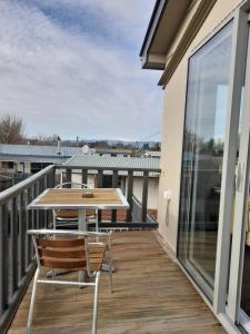 a patio with a table and chairs on a balcony at Colonial Motel in Twizel