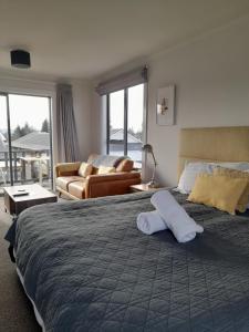 a hotel room with a large bed and a couch at Colonial Motel in Twizel