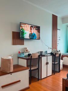 sala de estar con escritorio y TV en la pared en Albergo Condotel - AB Pagadian Enterprise, en Baguio