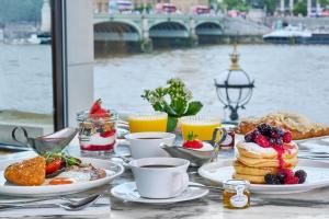 a breakfast table with pancakes and fruit and coffee at London Marriott Hotel County Hall in London