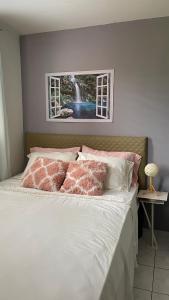 a bed with pink and white pillows and a window at Golden Meadows Oasis in Golden Spring