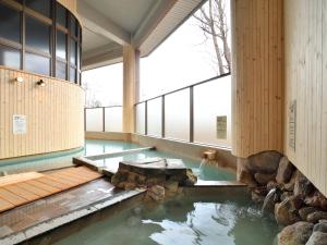 a pool in the middle of a building with a water feature at Oyado Kinkiyu in Teshikaga