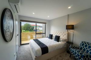 a bedroom with a bed and a large window at Sunnyhills Viewside Town House in Auckland