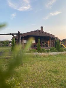 a building with a grass field in front of it at ХОМЕНЕ in Rzhyshchiv