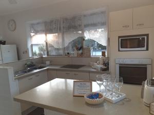 a kitchen with a counter with wine glasses on it at GUESTHOUSE on REGENT Bed & Breakfast in Caloundra