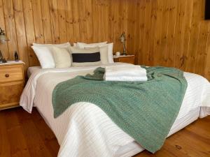 菲利港的住宿－Nest - charming, comfortable coastal villa，一张大床,上面有绿色和白色的毯子