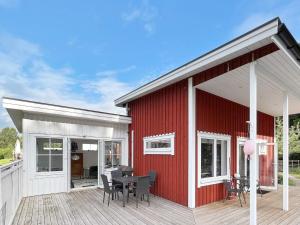 ein rotes und weißes Haus mit einer Holzterrasse in der Unterkunft Holiday home NISSAFORS 