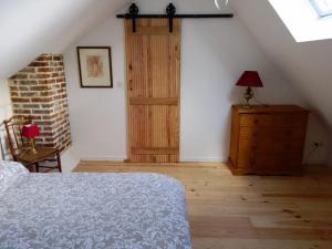 a bedroom with a bed and a dresser and a door at Logement du Coteau entre Beauval et Amboise in Faverolles-sur-Cher