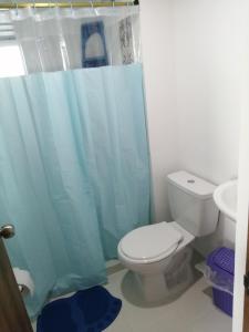 baño con aseo y cortina de ducha azul en Apartamento Eje Cafetero, en Armenia