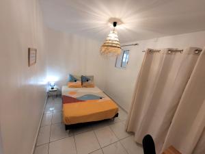Kleines Zimmer mit 2 Betten und einer Lampe in der Unterkunft KAZANVIL in Saint-Denis