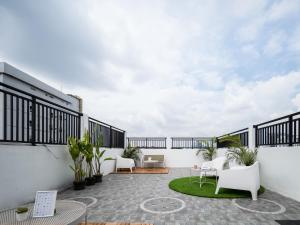 un patio al aire libre con paredes blancas y sillas blancas en Cove Taman, en Yakarta