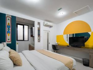 1 dormitorio con 1 cama grande y TV en Cove Taman, en Yakarta