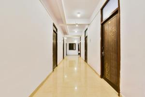 a hallway with black doors and white walls at OYO Flagship Ag Colony in Patna