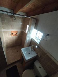 a bathroom with a sink and a toilet and a window at Cabaña vista al lago Tominė y Naturaleza Guatavita in Guatavita