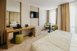 Habitación de hotel con 2 camas y escritorio en SPA Hotel Green Park en Garmen