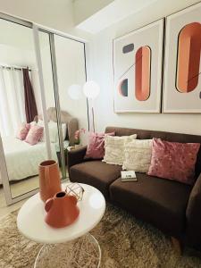 Suite M - 1 Bedroom Condo at Azure Residences في مانيلا: غرفة معيشة مع أريكة وسرير