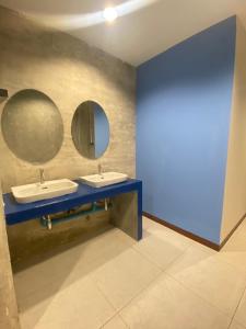 a bathroom with two sinks and two mirrors at Noc House in Bang Khlo
