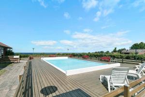 - une piscine sur une terrasse en bois entourée de chaises dans l'établissement Solsorten, à Hasle