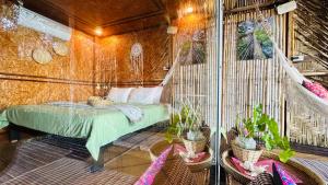 a bedroom with a bed in a room with plants at Deep House Sea View in Ko Lanta