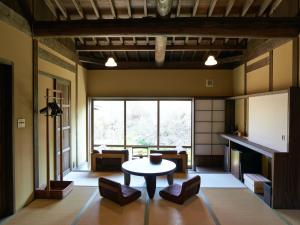 a living room with a table and chairs and a fireplace at kominka neri（古民家煉り） in Miyawaka