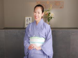 una mujer en un kimono sosteniendo su estómago en kominka neri（古民家煉り）, en Miyawaka