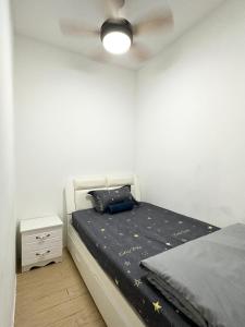 - une chambre avec un lit et un ventilateur de plafond dans l'établissement ITCC Manhattan Suites by Stay In 5-6pax, à Donggongon