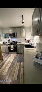 a kitchen with wooden floors and stainless steel appliances at Palmers Cozy Cottage mountainside getaway in Sutton