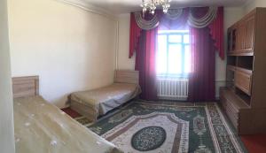 a room with a bed and a window and a rug at Welcome Guest House in Tokmok