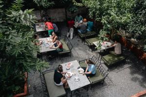 a group of people sitting at tables in a garden at Kwabahal Boutique Hostel in Kathmandu