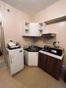 uma pequena cozinha com um frigorífico e um lavatório em C Comfortable Avida Room em Iloilo