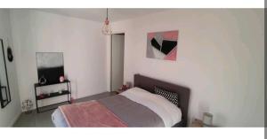 a bedroom with a bed and paintings on the wall at Superbe appartement avec jardin in Courrejean
