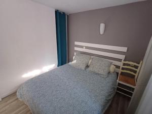 - une chambre avec un lit doté d'une couverture bleue et d'oreillers dans l'établissement Appartement de vacances en cerdagne, à Bourg-Madame