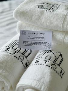 una pila de toallas blancas con una señal en ellas en Aston Residence Hatyai, 